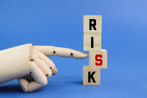 Finger, der einen Holzwürfel mit dem Wort Risiko drückt. das Konzept des Risikos oder der Herausforderung. Risiko im Geschäft