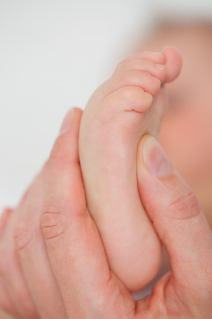 Finger, die den Fuß eines Babys berühren