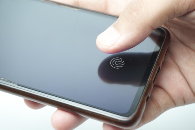 Foto fingerabdruckscanner auf dem telefonbildschirm. touchscreen-smartphone mit einer zone zum berühren des menschen