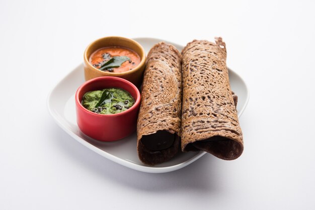 Foto fingerhirse oder ragi dosa ist ein gesundes indisches frühstück, serviert mit chutney, in rollen-, flach- oder kegelform
