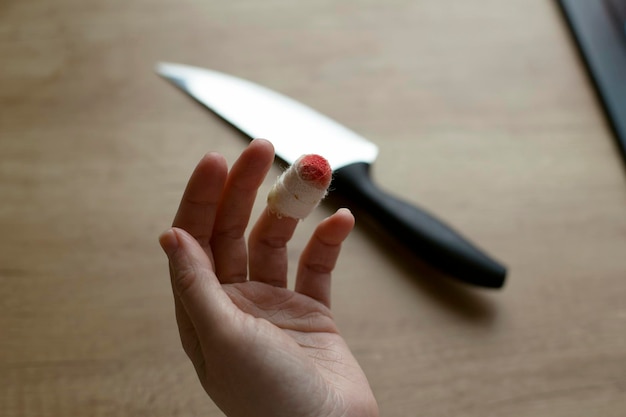 Foto fingerschnitt mit einem messer zu hause frauenhand und ein verband am ringfinger