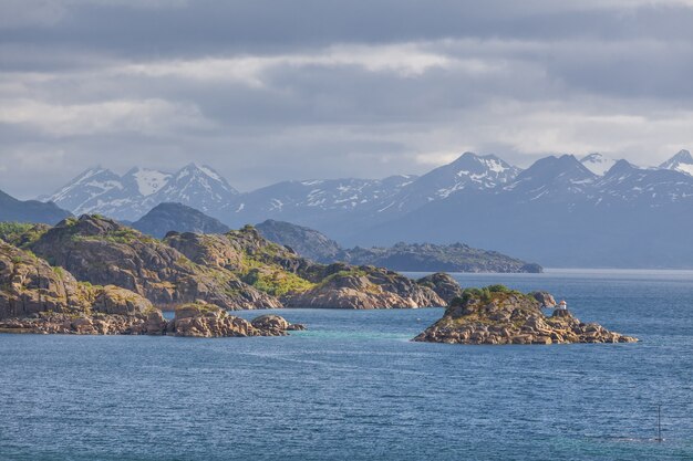 Fiorde norueguês e montanhas cercadas por nuvens, reflexo ideal de fiorde em águas claras