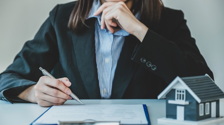 Firma manual del contrato después de que el agente de bienes raíces explica al comprador el contrato comercial, el alquiler, la compra, la hipoteca, el préstamo o el seguro del hogar.