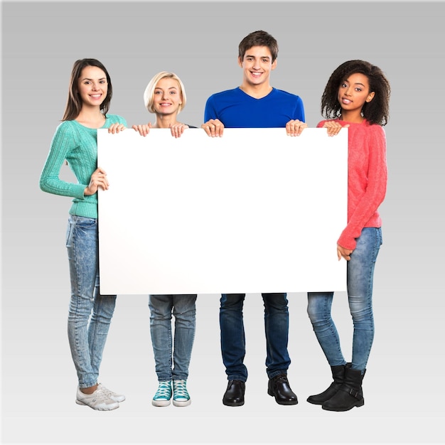 Foto firmar estudiante universitario sosteniendo adolescente en blanco grupo de personas