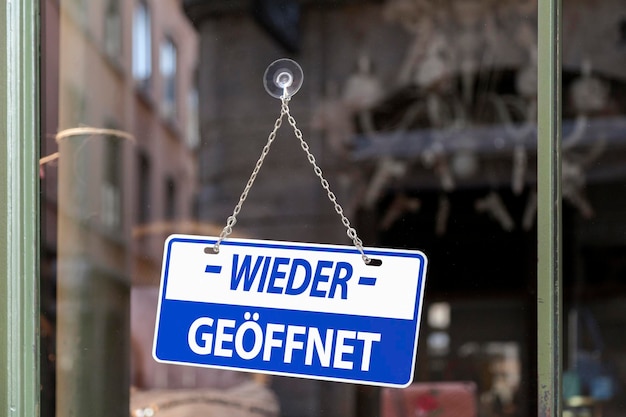 Foto firmar en una ventana escrita en el interior en alemán wieder geoffnet significado en inglés abierto de nuevo
