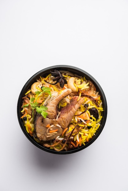 Fisch Biryani oder Pulao im Restaurantstil verpackt für die Lieferung nach Hause in einer Plastikbox oder einem Behälter mit Raita und Salan