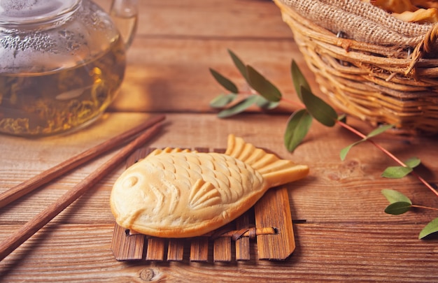 Fisch-förmige süße füllende Waffel des japanischen Straßenlebensmittels Taiyaki auf Holztisch