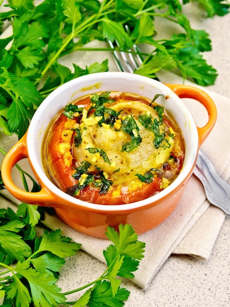 Fisch gebacken mit Tomaten und Knoblauch im roten Topf auf dem Tisch