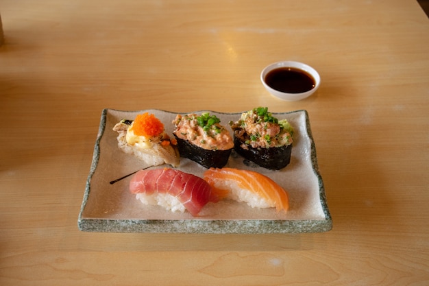 Fisch-Sushi eingestellt in keramische Platte auf Holztisch.