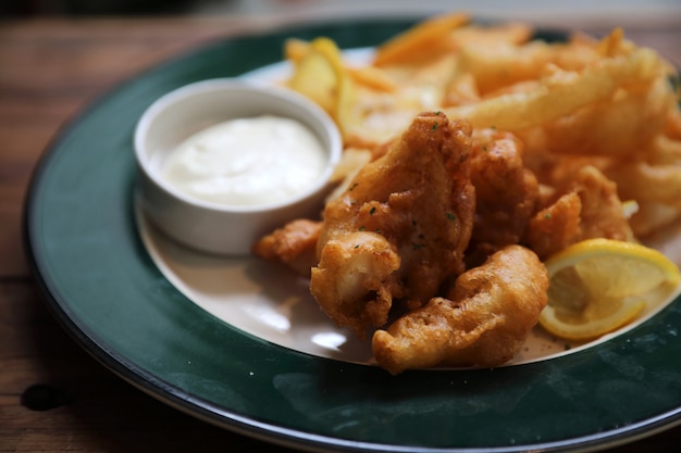 Fisch und gebratene Fische und Kartoffeln auf hölzerner Hintergrundweinleseart