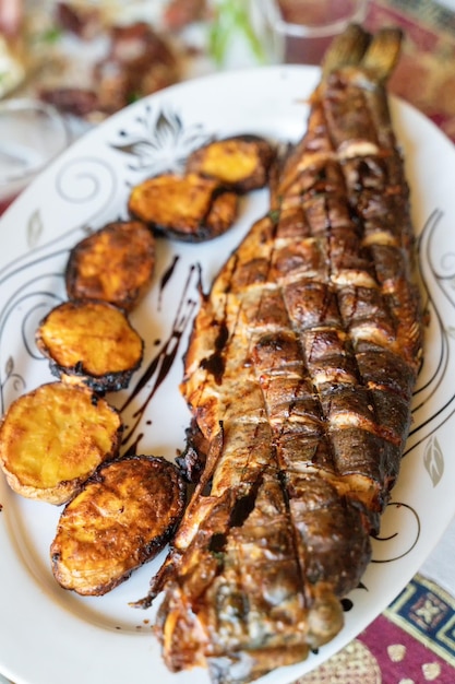 Fisch und Kartoffeln im traditionellen türkischen und kaukasischen Tandoor gekocht