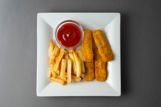 Fisch und mit Pommes-Frites - ungesundes Lebensmittel, graues backgrpound.