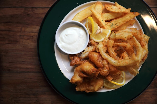 Fisch und Pommes frittierter Fisch und Kartoffeln auf Holz Hintergrund Vintage-Stil