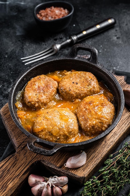 Fischbällchen mit Thunfisch in Tomatensauce in einer Pfanne Schwarzer Hintergrund Ansicht von oben