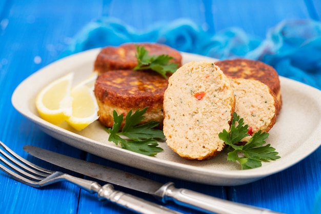 Foto fischbällchen mit zitrone auf teller auf holztisch