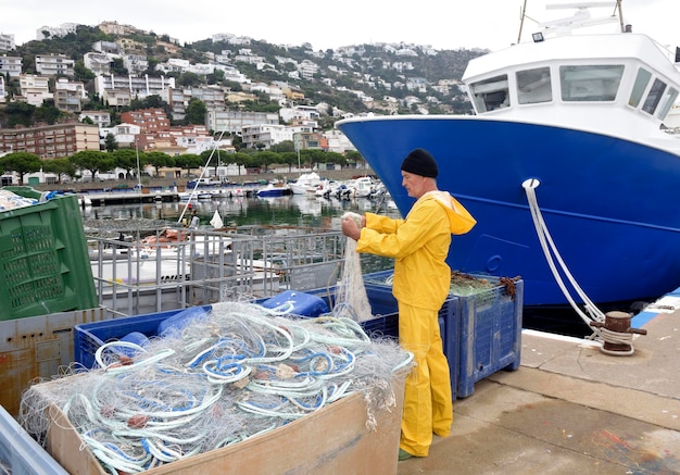 Fischer repariert die Netze im Hafen