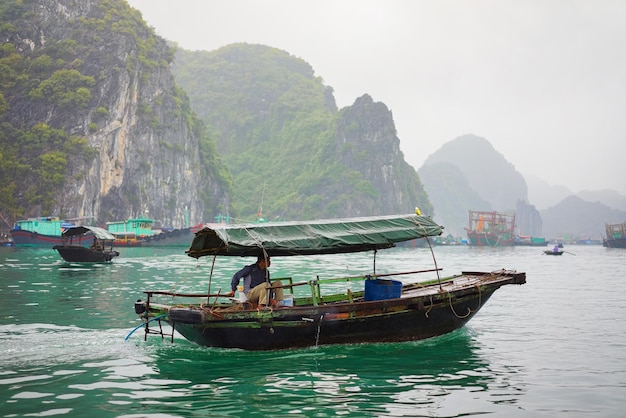 Fischerboot in Ha Long Bay, Vietnam, Asien. Kalksteininseln im Hintergrund