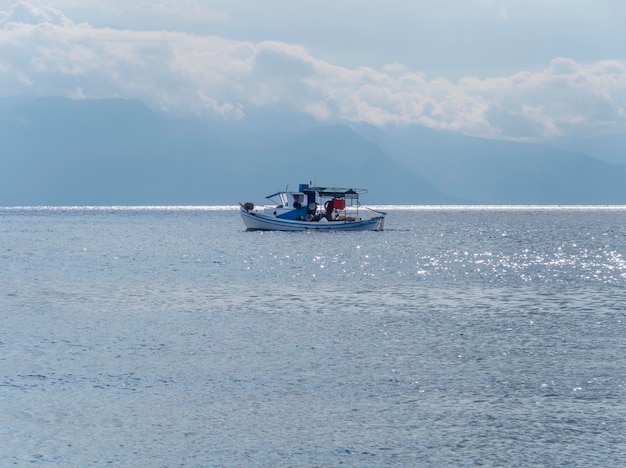 Fischerboot und Angeln bei Sonnenuntergang in der Ägäis in der Nähe der Insel Euböa in Griechenland