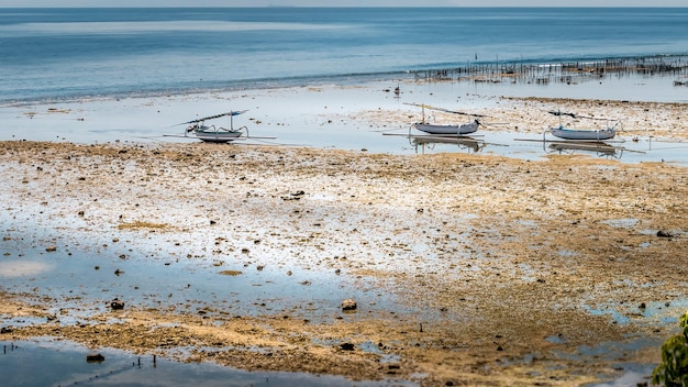 Fischerboote bei Ebbe in der Nähe von Algenplantagen Nusa Penida Bali Indonesien