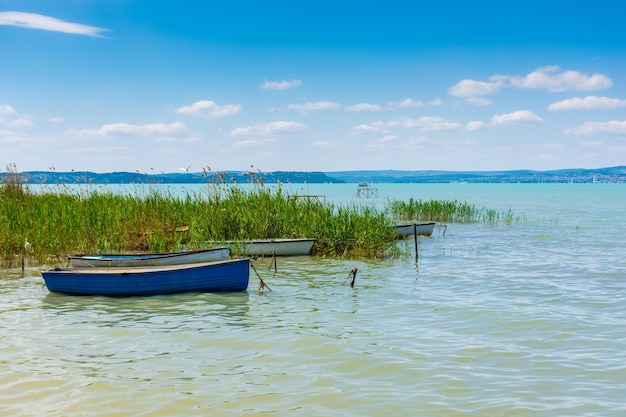 Fischerboote sind am Ufer eines Sees mit türkisfarbenem Wasser festgemacht