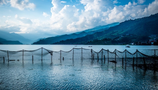 Fischernetz gezogen in einer Leine auf dem Phewa-See Pokhara, schöne Aussicht auf die Berge im Hintergrund