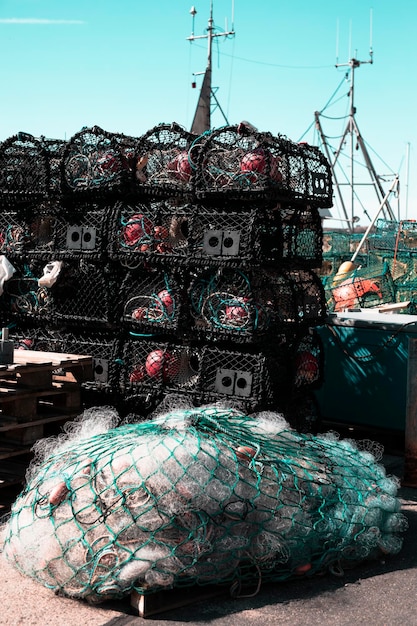 Fischernetze gestapelt auf dem Pier in einem Hafen Nahaufnahme Hintergrund Fischernetz und Boot