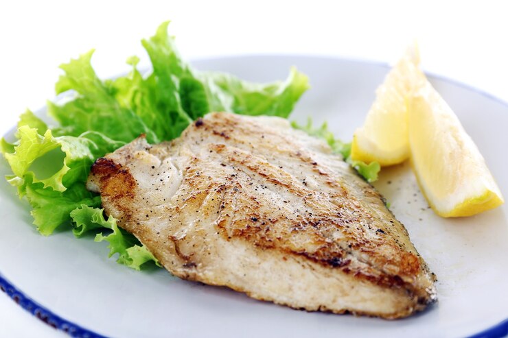 Foto fischfiletschale mit salat und zitrone auf teller nah oben