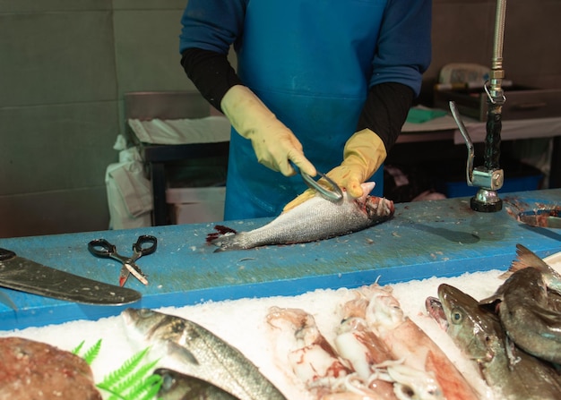 Foto fischhändler schuppen den fisch in den fischhandler