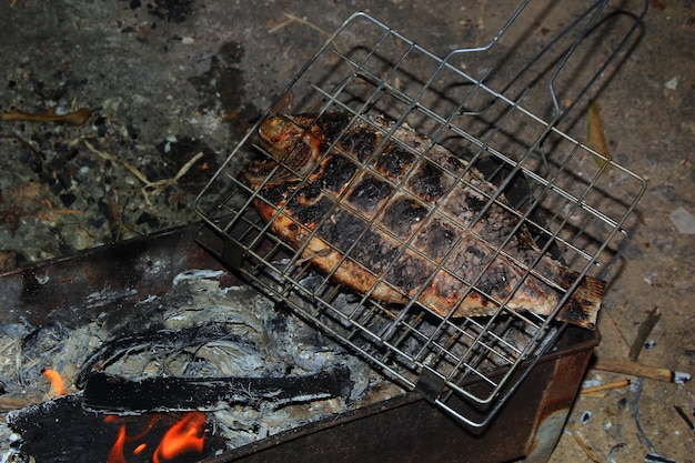 Fischschuppen verbrannten auf einem heißen Kohleofen.