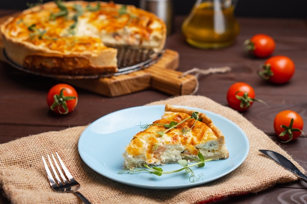 Fischtörtchen Stück französischer Kuchen mit Lachs und Käse Quiche Lauren mit abgeschnittenem Stück rotem Fisch