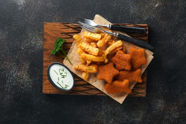 Fish and Chips britisches Fast Food Fischstäbchen mit Pommes Frites auf rustikalem Brett auf dunklem alten Betonhintergrund Traditionelles britisches authentisches Straßenessen oder Essen zum Mitnehmen Mock-up Draufsicht