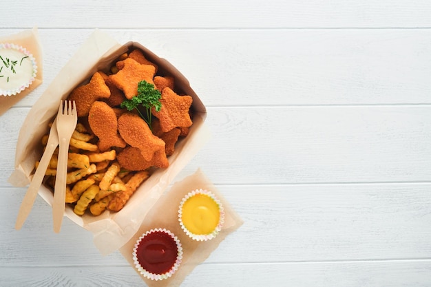 Fish and Chips comida rápida británica Palitos de pescado con papas fritas en un plato de papel para llevar sobre fondo blanco de madera Comida callejera auténtica tradicional británica o comida para llevar Maqueta