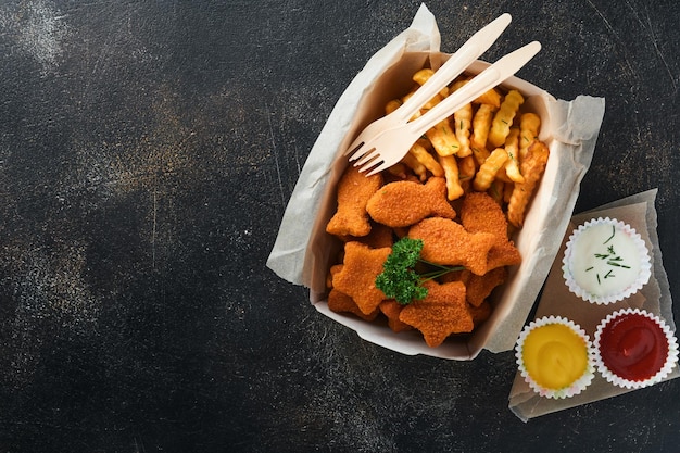 Fish and Chips fast food britânico Fish Sticks com batatas fritas em prato de papel para viagem no fundo escuro de concreto velho Comida de rua autêntica britânica tradicional ou comida para viagem Mock up