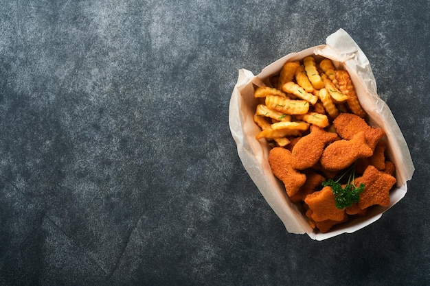 Fish and Chips fast food britânico Fish Sticks com batatas fritas em prato de papel para viagem no fundo escuro de concreto velho Comida de rua autêntica britânica tradicional ou comida para viagem Mock up