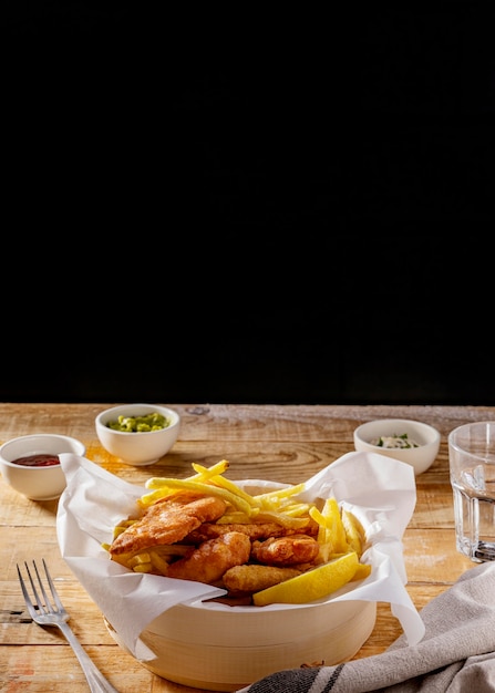 Fish and chips con salsas y copie el espacio.