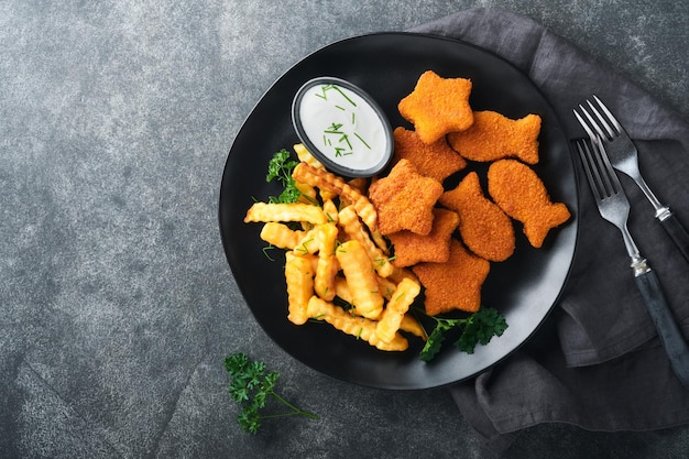 Fish Chips britisches Fast Food Fischstäbchen mit Pommes frites auf schwarzem Teller auf schwarzem Tischhintergrund Traditionelles britisches authentisches Straßenessen oder Essen zum Mitnehmen Mock-up mit Platz für Text