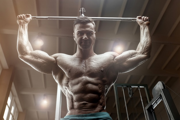 Fisiculturista à moda antiga fazendo exercícios de flexões no ginásio. estilo de homem bonito esportes caucasiano dos anos 80. conceito de esporte, fitness e treino dos anos 80