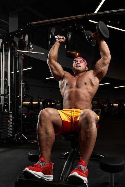 Fisiculturista bonito forte atlético homem áspero bombeando músculos abdominais treino fitness e musculação conceito saudável fundo