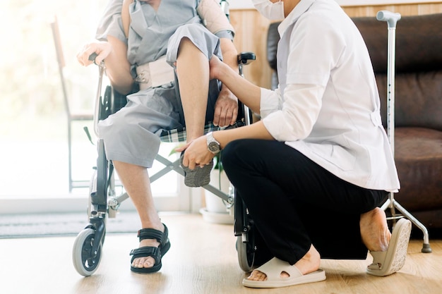 Fisioterapeuta ayudando a una anciana con andador en gimnasia correctiva