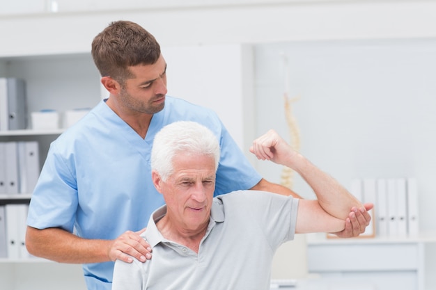 Fisioterapeuta dando fisioterapia ao homem
