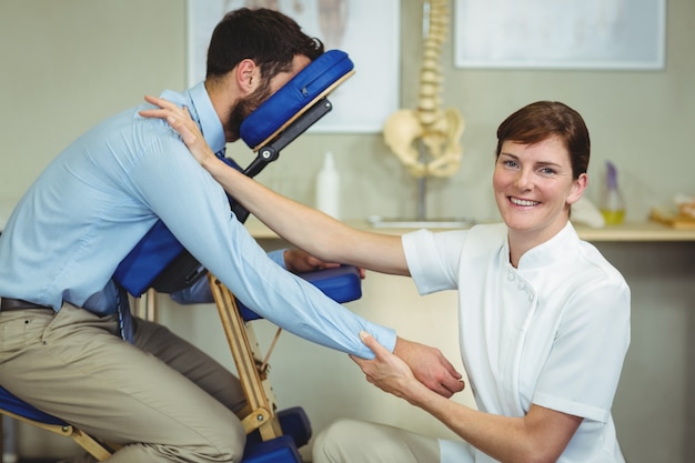 Fisioterapeuta dando masaje de brazo a un paciente