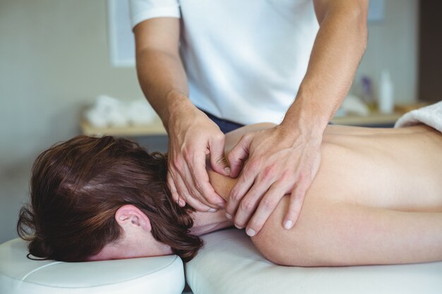 Fisioterapeuta dando masaje de cuello a una mujer