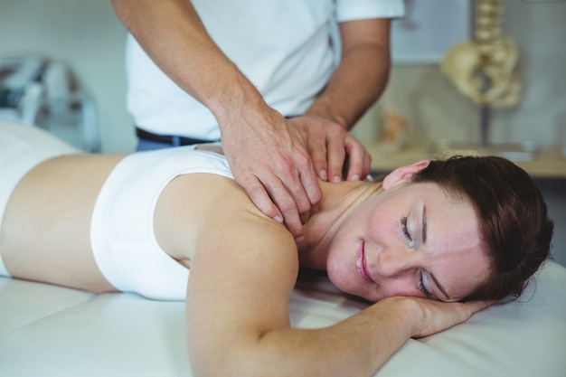 Fisioterapeuta dando masaje de cuello a una mujer