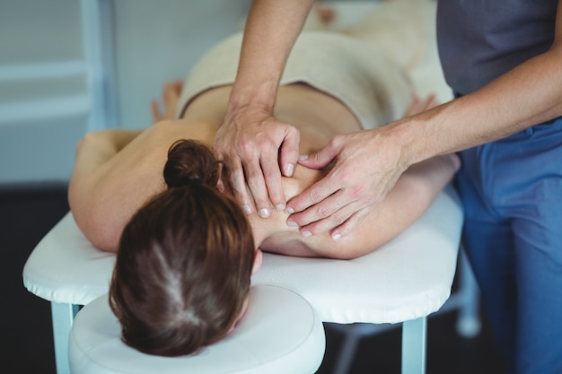 Fisioterapeuta dando masaje de cuello a una mujer