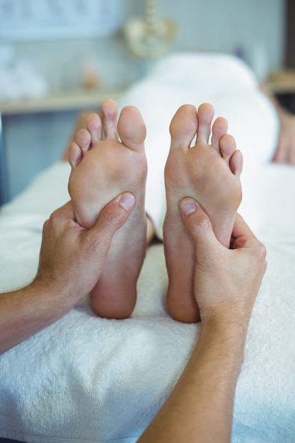 Foto fisioterapeuta dando massagem nos pés para uma mulher