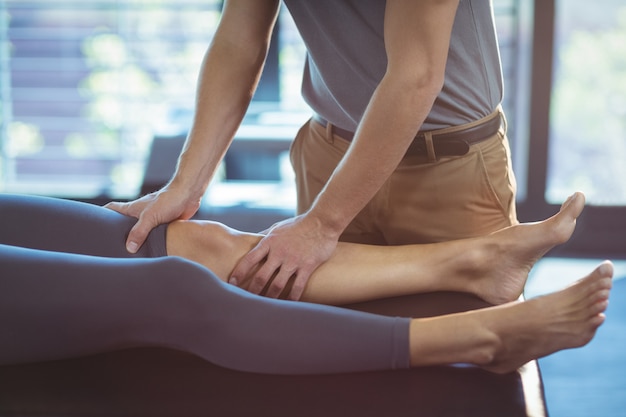 Fisioterapeuta dando terapia de rodilla a una mujer