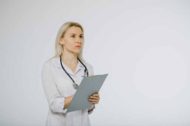 Fisioterapeuta escribiendo en portapapeles en clínica. Doctor escribiendo en un portapapeles