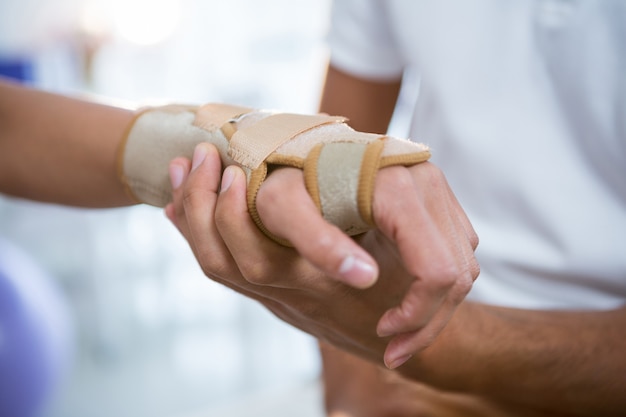 Fisioterapeuta examinando la mano de una paciente