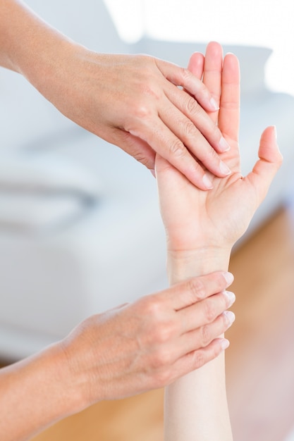 Fisioterapeuta examinando la mano de sus pacientes