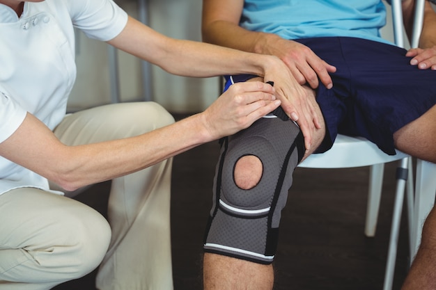 Fisioterapeuta examinando pacientes joelho